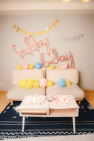 誕生日バルーンやガーランド、花びらで飾り付けられた部屋