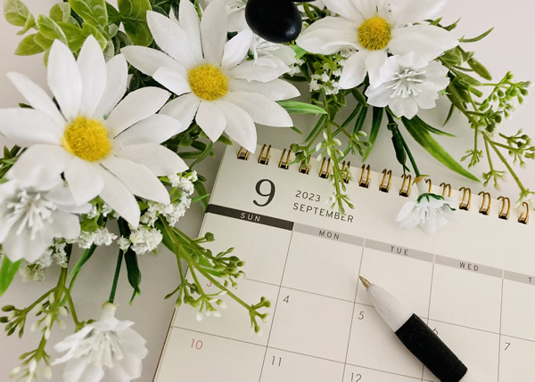 卓上カレンダーに白い花が添えられている様子